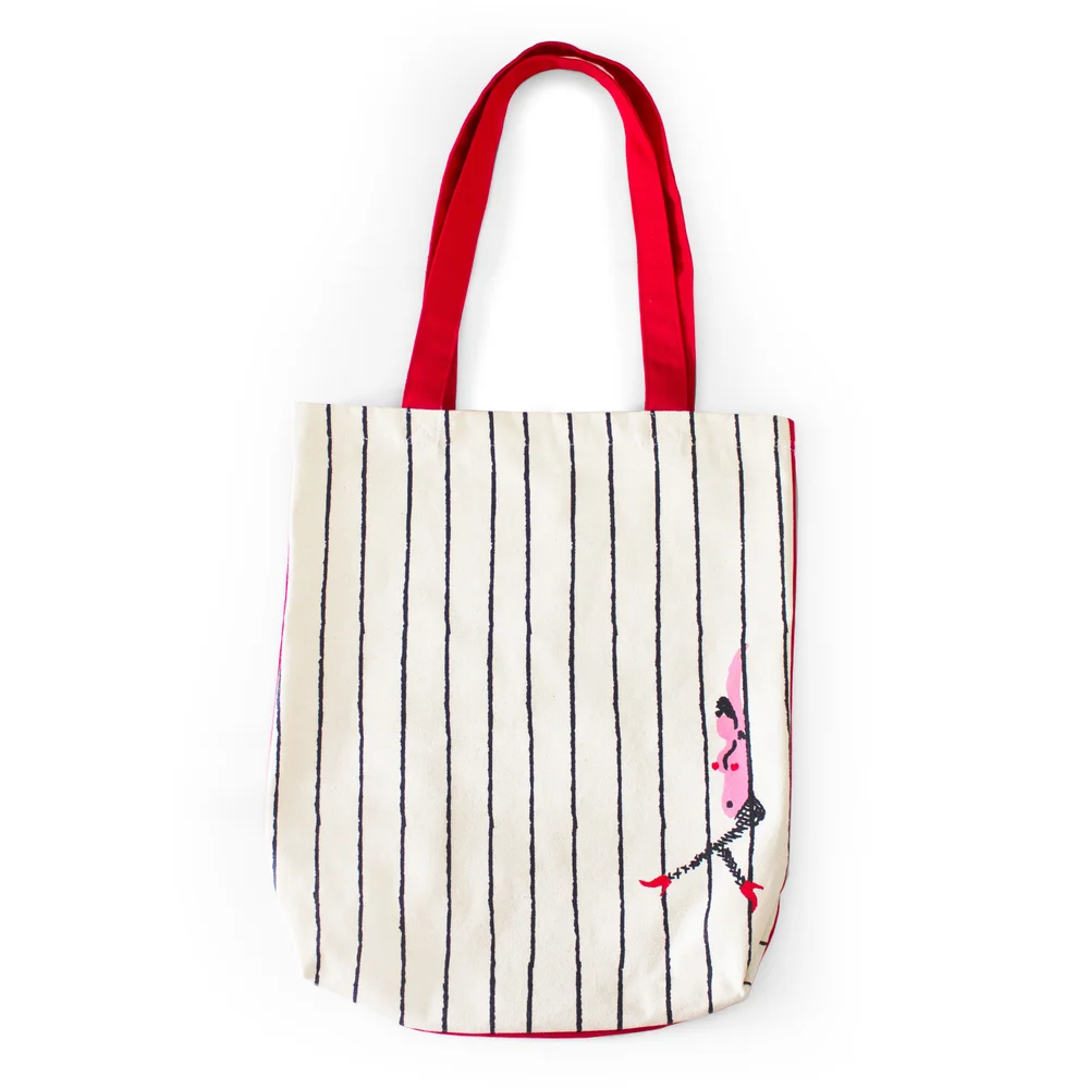 Soft cream-toned canvas with gentle vertical stripes and warm red accents, arranged on a neutral surface in a clean editorial style